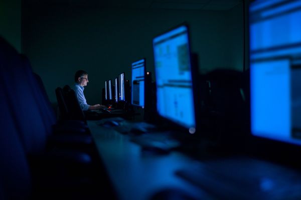 Person in dark room working on computer