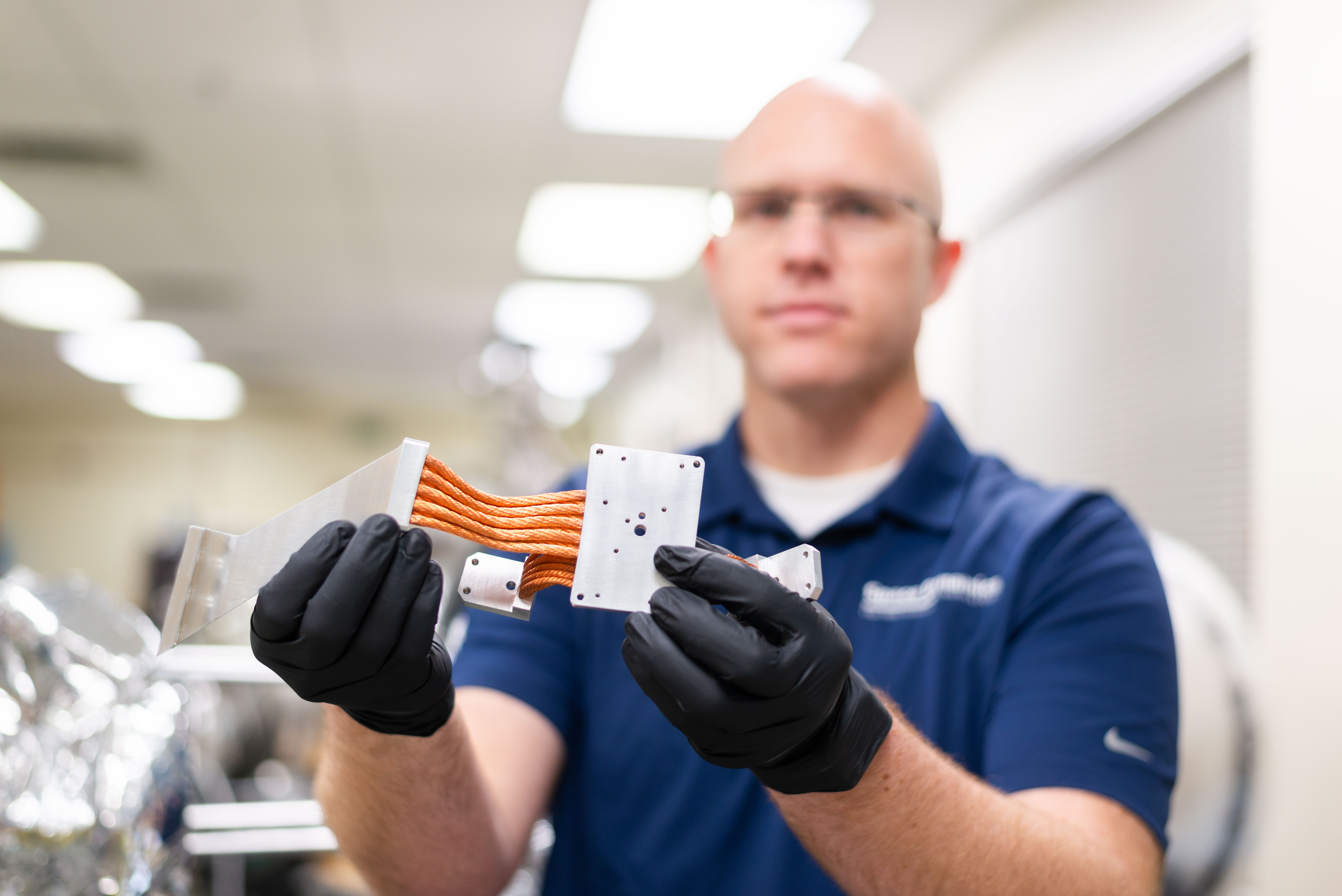 Matt holds up a copper braid thermal strap.