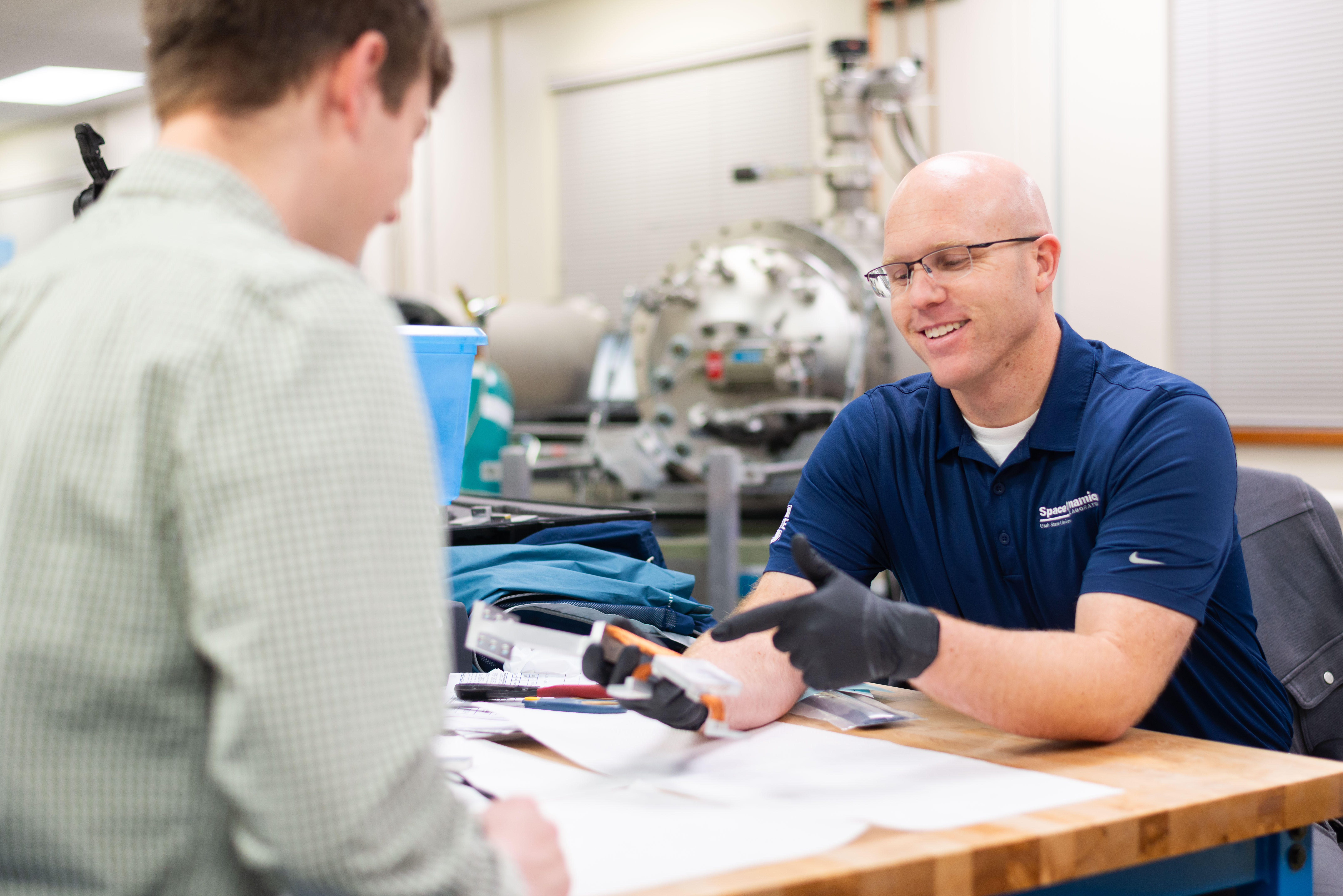 Matt and coworker discuss a thermal strap design.