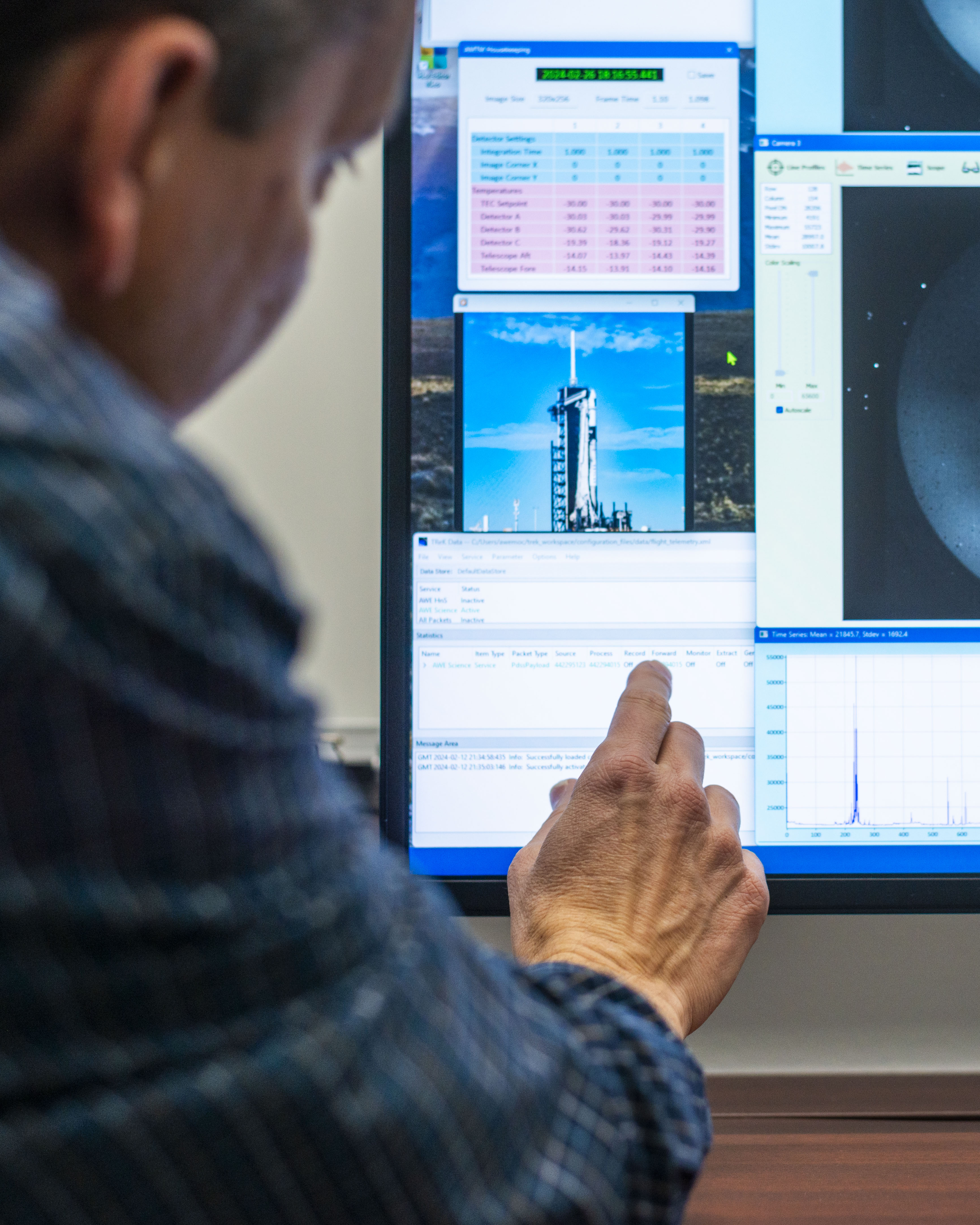 Pedro points to and explains the the software he created and uses at the AWE mission operations center.